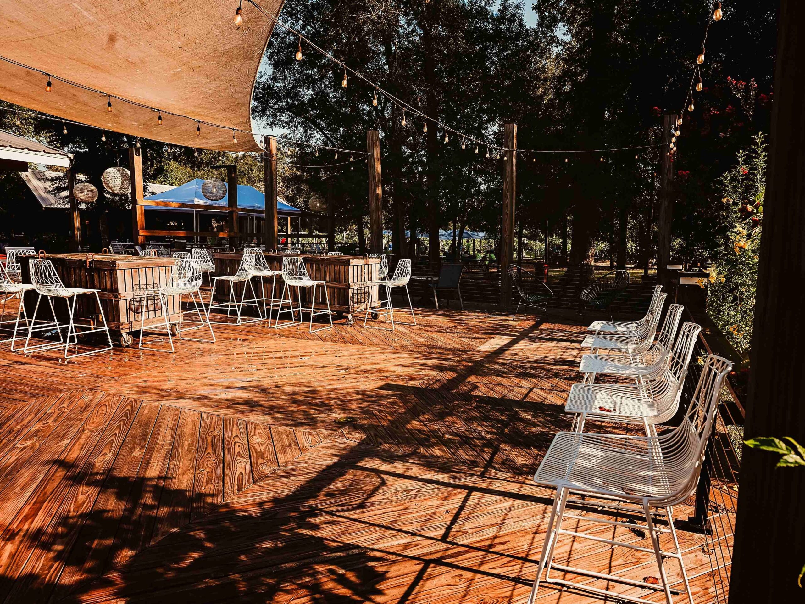 Outdoor wooden deck with chairs and string lights for events and gatherings.